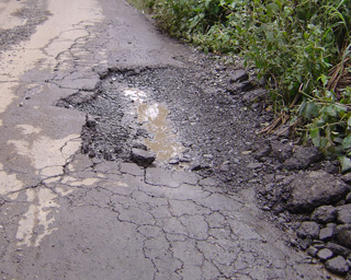 道路の舗装がはがれている写真